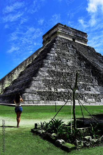 tourist woman taken pictures of
 the pyramids of chichen itza in mexico