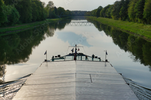 ship's bow on a canal with a bridge