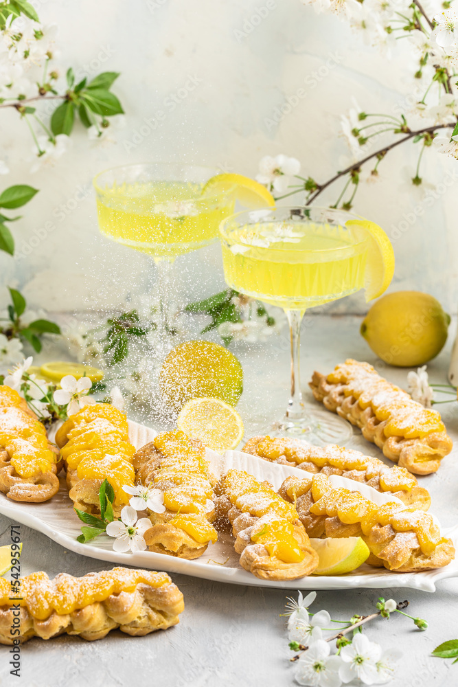 Traditional French dessert eclairs with lemon curd topping. Limoncello italian lemon liqueur, Restaurant menu, dieting, cookbook recipe top view Traditional French dessert eclairs with lemon curd topping. Limoncello italian lemon liqueur, Restaurant menu, dieting, cookbook recipe top view