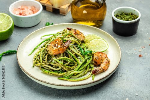 Pasta spaghetti zucchini basil pesto sauce and grilled shrimp, Vegetarian vegetable pasta, Food recipe background. Close up