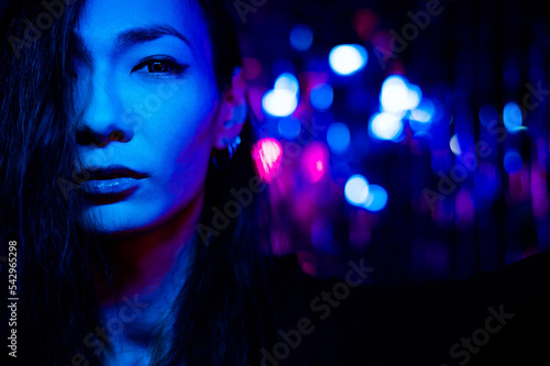 Portrait of a transgender model in a studio with neon lighting.