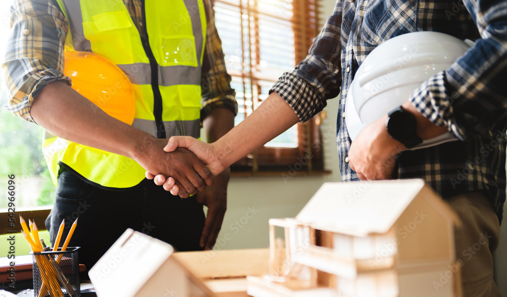 Engineer and contractor join hands after signing contract,They are having a building project together. successful cooperation concept. Engineer and contractor join hands after signing contract,They are having a building project together. successful cooperation concept.