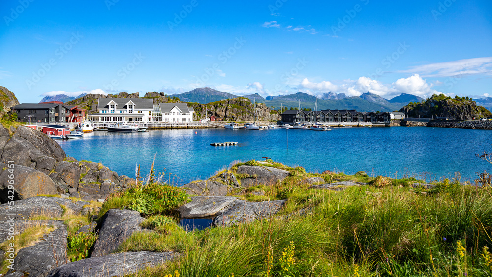 panorama of a small village with a marina on the lofoten islands in norway, the norwegian fjords with mighty mountains above the sea