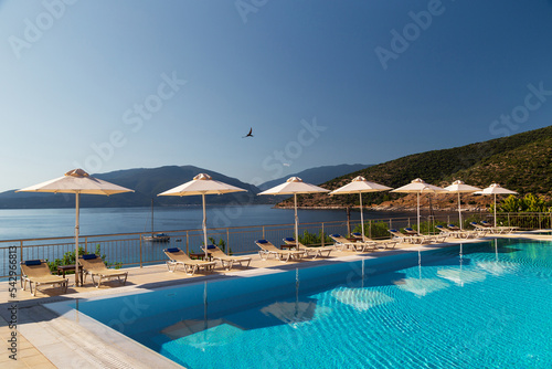 Print op canvas Luxury swimming pool with empty deck chairs and umbrellas at resort with beautiful sea view