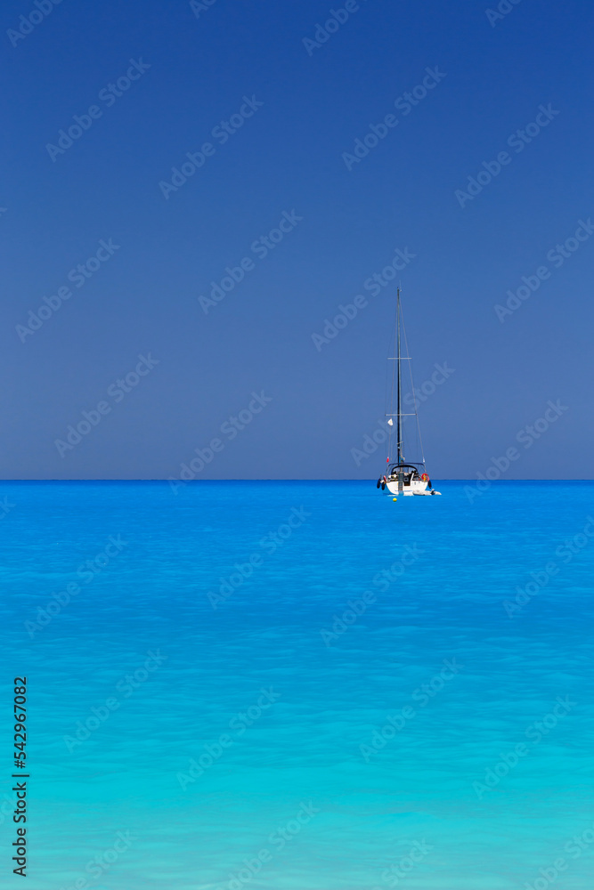 White yacht anchored in fantastic Myrtos Beach turquoise and blue bay. Summer scenery of famous and extremely popular travel destination in Cephalonia island, Greece, Europe. White yacht anchored in fantastic Myrtos Beach turquoise and blue bay. Summer scenery of famous and extremely popular travel destination in Cephalonia island, Greece, Europe.