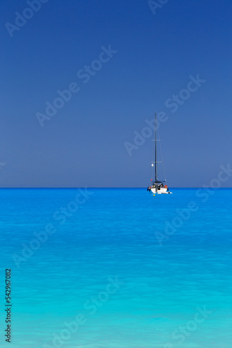 White yacht anchored in fantastic Myrtos Beach turquoise and blue bay. Summer scenery of famous and extremely popular travel destination in Cephalonia island, Greece, Europe.
