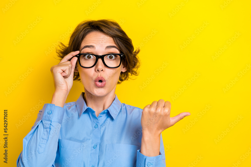 Closeup photo of young funny millennial woman finger point empty space good product low price genius idea touch glasses isolated on yellow color background Closeup photo of young funny millennial woman finger point empty space good product low price genius idea touch glasses isolated on yellow color background