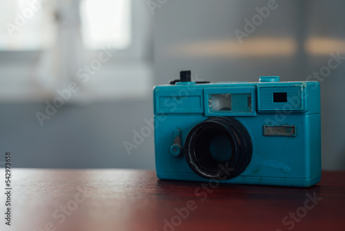 a blue toy camera on a wooden table