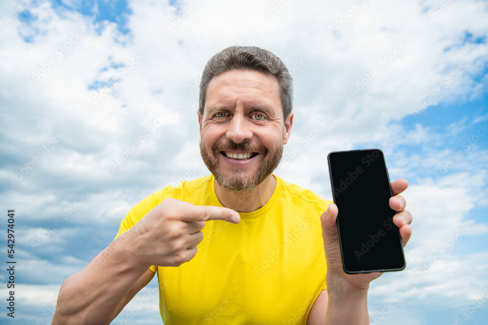 happy man presenting screen of smartphone with copy space happy man presenting screen of smartphone with copy space