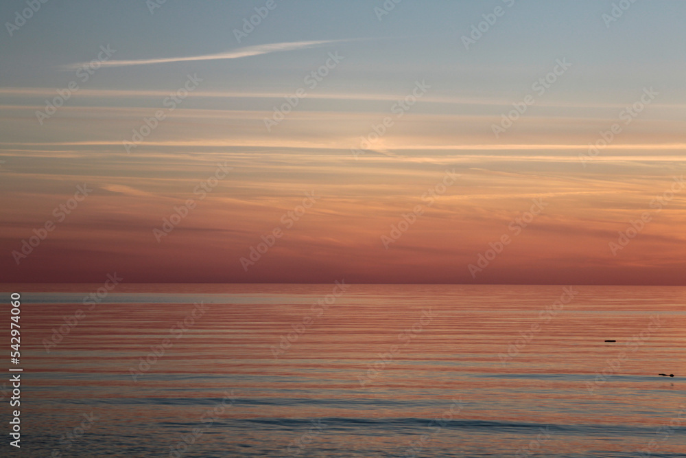 Sunsetting sky above calm sea during the dusk. Selective focus