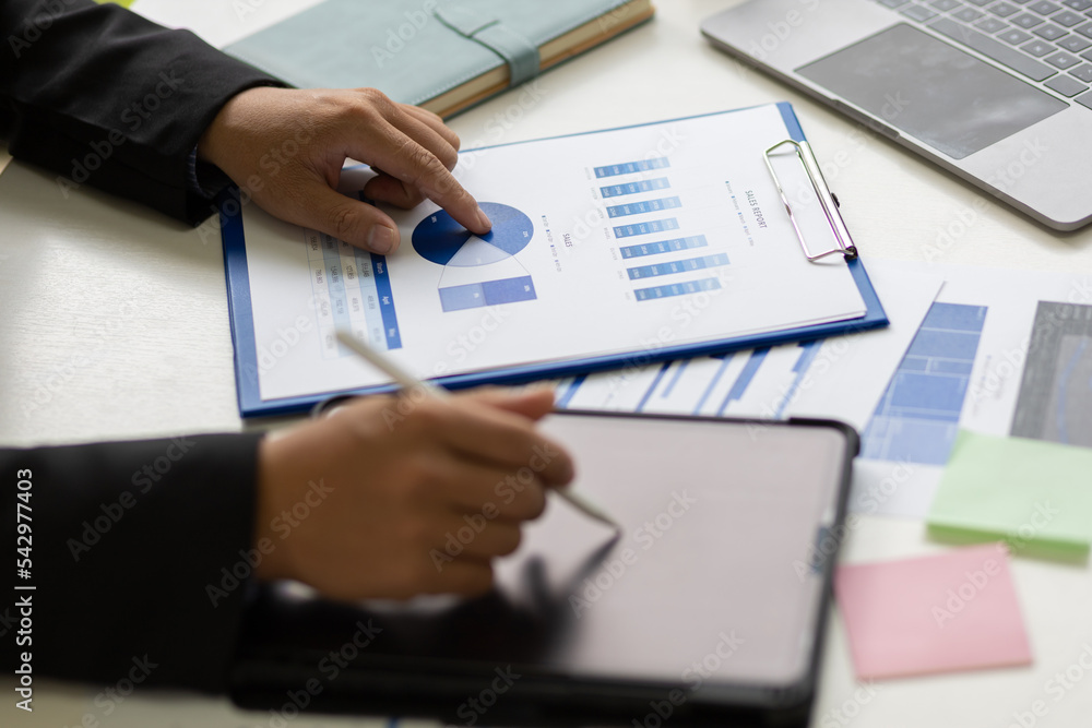 Businessman analyzes company marketing growth data and makes investment plans on tablet. Sales strategy analysis and business investment planning. Businessman analyzes company marketing growth data and makes investment plans on tablet. Sales strategy analysis and business investment planning.