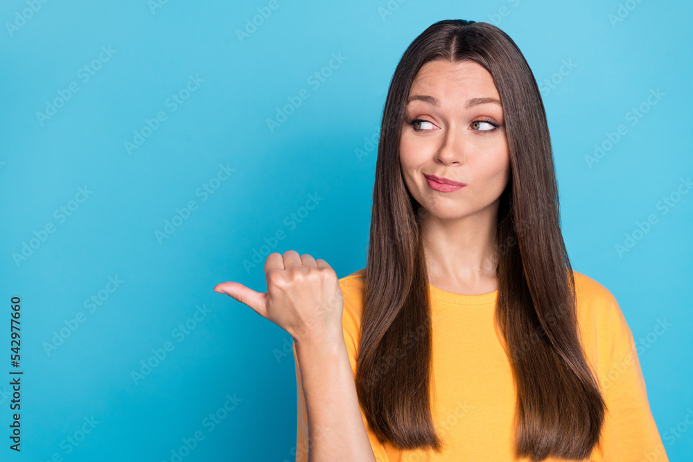 Fototapeta premium Portrait of cute nice positive girl wear yellow t-shirt look indicating empty space unbelievable sale isolated on blue color background