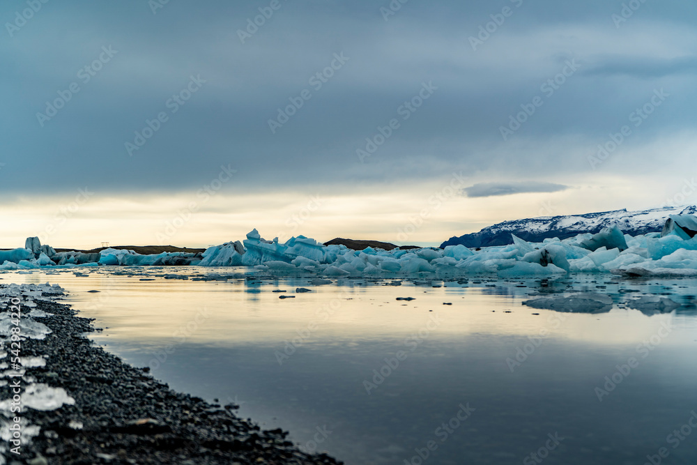 black beach blue ice and sunset with ocean on background