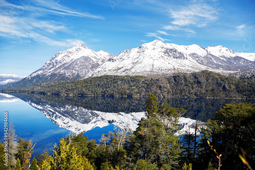 panorama of lago gutierrez with the mirrored lake on a sunny day, mountains with green forests. Snowy cathedral hill in the background photo