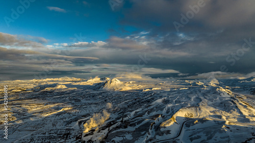 Obraz na płótnie aerial view on morning winter beautiful mountains covered with snow in iceland with steam from geothermal plant w salonie