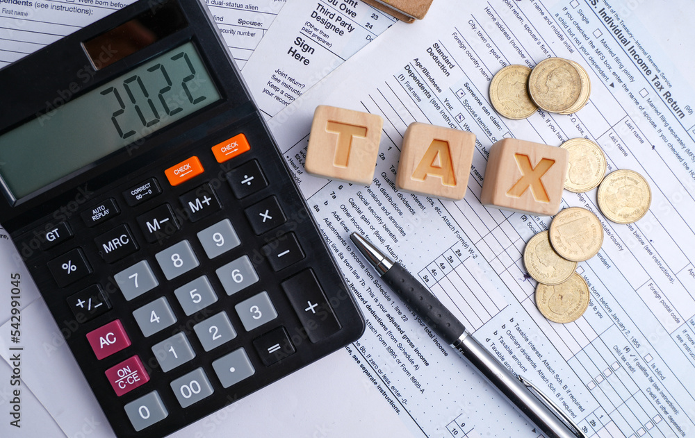 Tax words and numbers 2021 are displayed on a calculator and orange paper. Letters on wooden blocks, business ideas and taxes. Pay taxes in 2022. New year tax ideas. Tax words and numbers 2021 are displayed on a calculator and orange paper. Letters on wooden blocks, business ideas and taxes. Pay taxes in 2022. New year tax ideas.