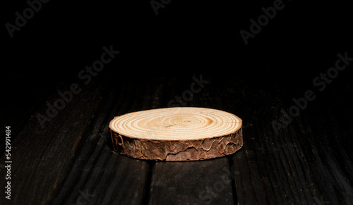 Natural wood podium on dark table with space for your product mockup