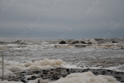 Large waves crashing onto the beach during a storm with a dramatic sky background. Taken in Cleveleys Lancashire England.  photo