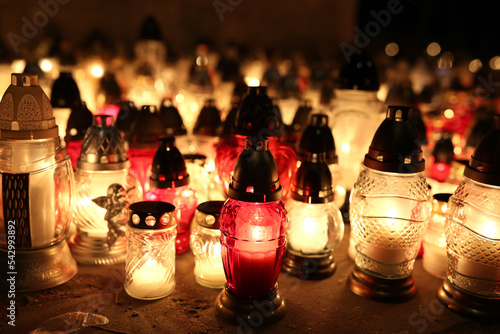 Znicze na grobie osoby bliskiej świeci podczas święta zmarłych wieczorem. Światło.
