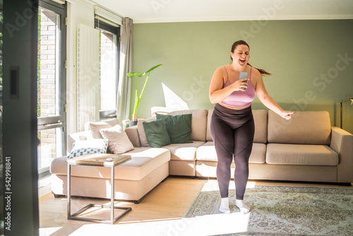Wallpaper Mural Overjoyed woman singing in smartphone like at microphone and dancing Torontodigital.ca