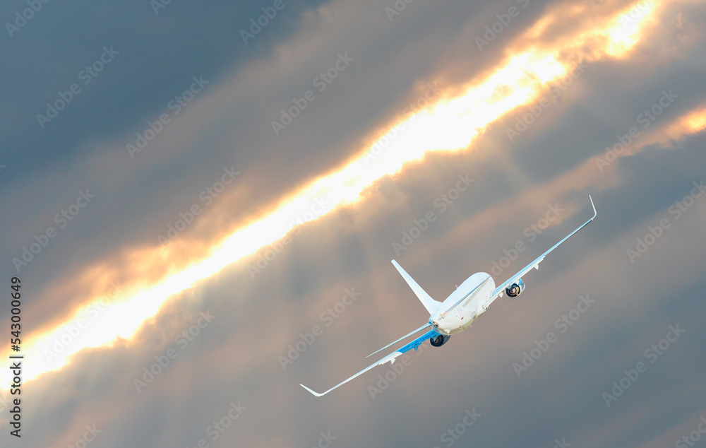 Airplane in the sky at sunset Stock Photo | Adobe Stock