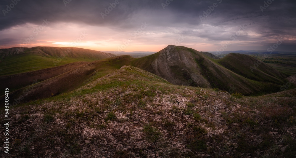 Panoramic view of mountains under dramatic sky at sunrise