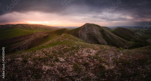 Panoramic view of mountains under dramatic sky at sunrise