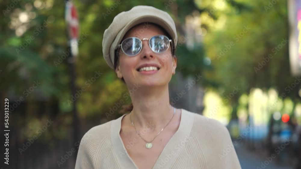 Young attractive girl in a cap and sunglasses walking on an autumn street Young attractive girl in a cap and sunglasses walking on an autumn street
