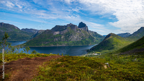 view from the hesten trailhead of the town of fjordegard and the mighty mountains in the norwegian fjord on the island of senja photo