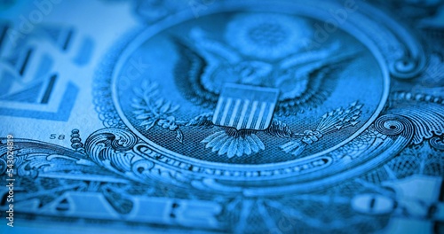 Back side of paper dollar bill with eagle emblem in soft focus. One dollar banknote. Macro shot of american dollar. American currency, greenback, cash. Money background in blue tint.