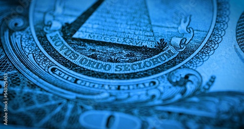 One dollar paper banknote in blue soft light. Macro shot of part of 1 dollar bill with symbol pyramid and motto novus ordo seclorum. U.S. currency with the fifth president George Washington. photo