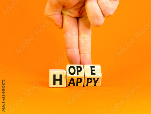 Hope and happy symbol. Concept words Hope and Happy on wooden cubes. Beautiful orange table orange background. Businessman hand. Business hope and happy concept. Copy space.