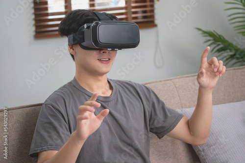 relieve stress on vacation Happy Asian white man relaxing at home playing VR 3D virtual reality game on vacation.