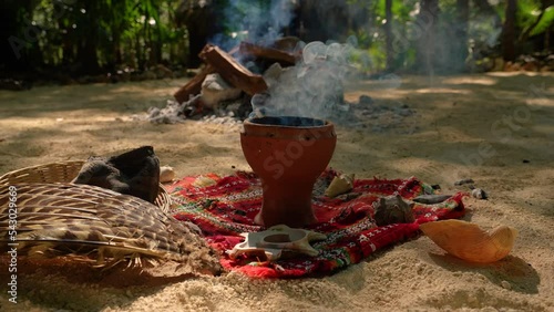 Temazcal Bowl  for the Mexican steam bath Temazcal. Clay bowl from which smoke enters. In the background, a fire is burning, in which volcanic coal is heated for the Mexican steam bath - Temazcal