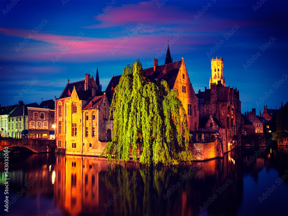 Famous view of Bruges - vintage retro effect filtered hipster style image of Belfry and old houses along canal with tree. Brugge, Belgium