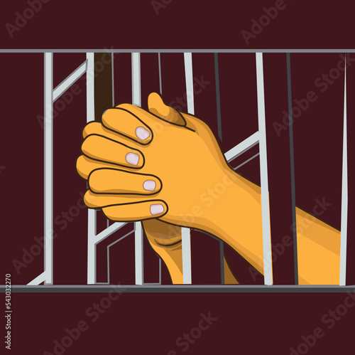 two hands praying behind bars in prison


