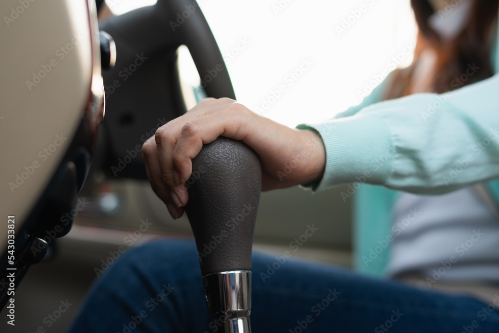 Hand female driver using automatic gear shift system in car. Woman shifting an automatic car. Hand female driver using automatic gear shift system in car. Woman shifting an automatic car.