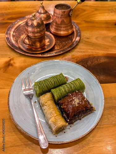 Turkish coffee and delicious, baklava, copper cezve, authentic arabic  coffee utensil set, coffee pot on wooden table photo