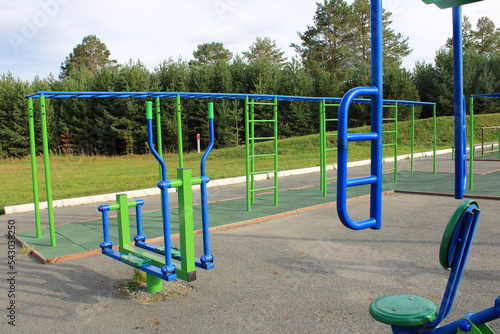 Sports street playground with exercise equipment against the backdrop of a green forest. The concept of a healthy lifestyle.