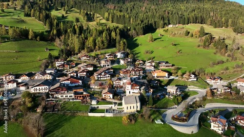 Small town on top of a mountain, surrounded by green pastures, in the European Alps. photo