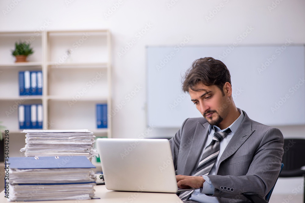Young businessman employee and too much work in the office Young businessman employee and too much work in the office
