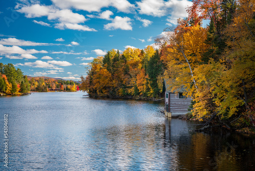 Print op canvas Autumn leaves and trees surround boathouse on Chateaugay Lake in Ellenburg New Y