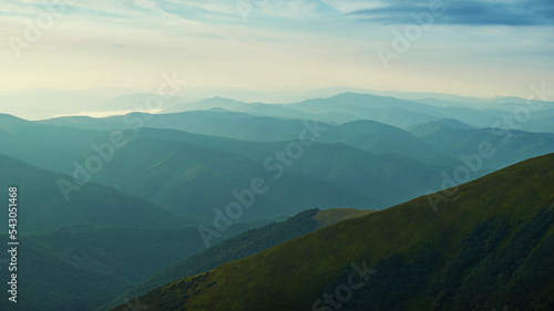 Early morning in the Carpathian mountains. A chain of mountain ranges dissolve in the morning foggy haze