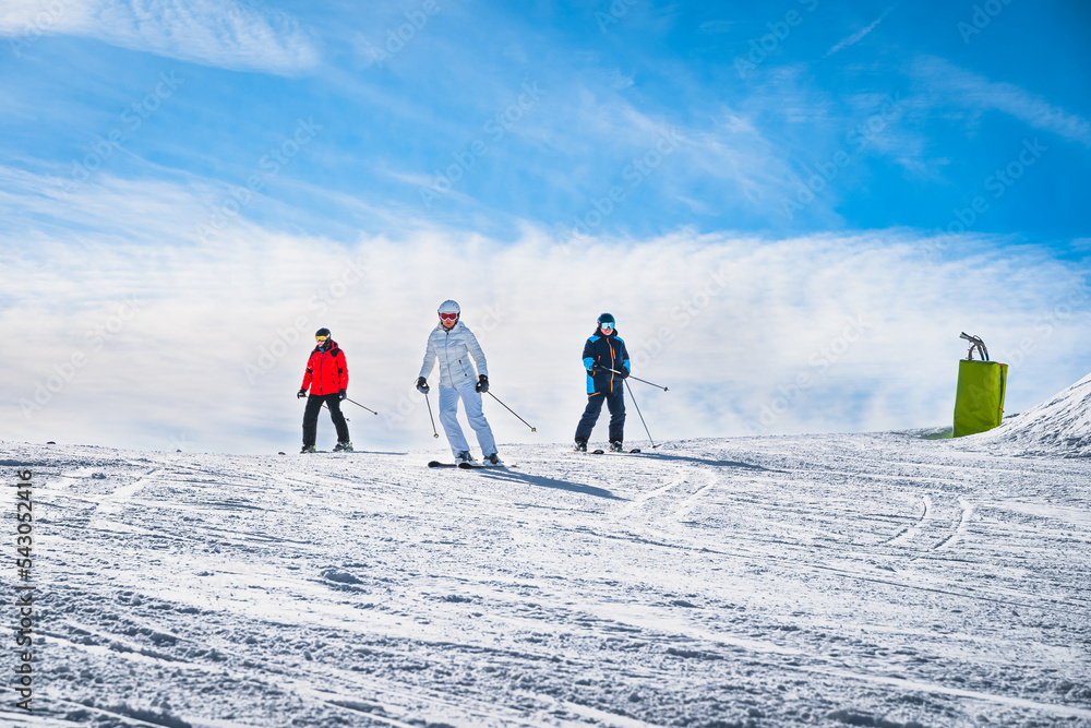 Man and woman skiing down the ski slope or piste in Pyrenees Mountains. Winter ski holidays in El Tarter, Grandvalira, Andorra