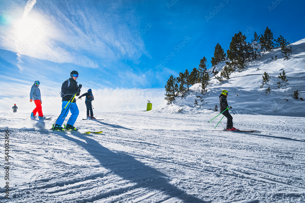 Group of people skiing and snowboarding down the ski slope or piste in Pyrenees Mountains. Winter ski holidays in El Tarter, Grandvalira, Andorra - obrazy, fototapety, plakaty 