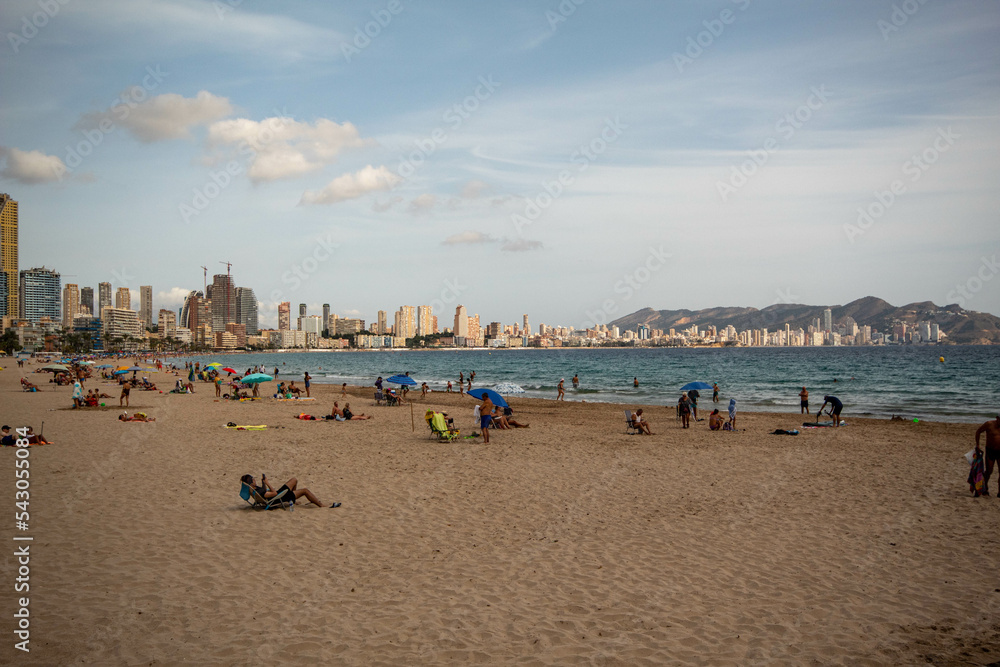 Panorámica del paisaje marítimo de la ciudad de Benidorm con su playa bajo un cielo azul con algunas nubes y el tranquilo mar en el último viaje de trabajo. Panorámica del paisaje marítimo de la ciudad de Benidorm con su playa bajo un cielo azul con algunas nubes y el tranquilo mar en el último viaje de trabajo.