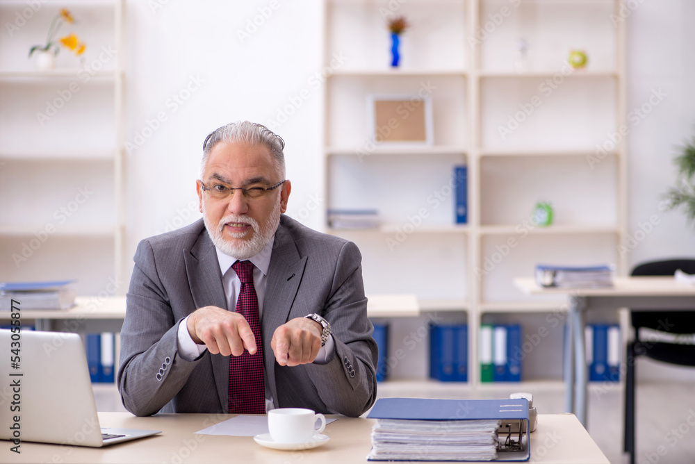 Old male employee drinking coffee during break Old male employee drinking coffee during break