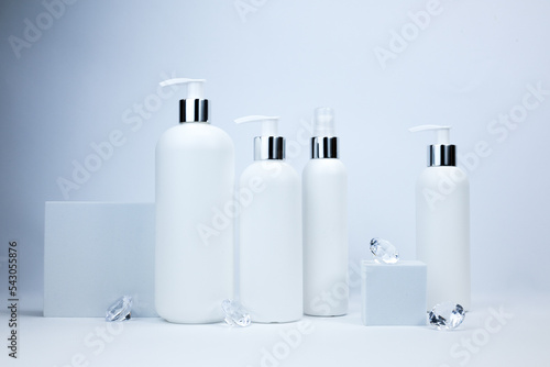 Set of white cosmetic bottles mockup. White plastic bottles with shampoo and conditioner and shower gel on a white background. Mockup cosmetic bottle with crystals on white background