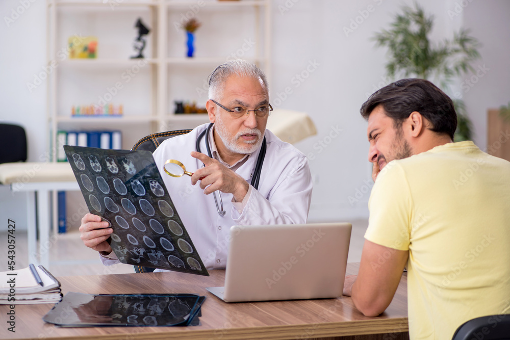 Young male doctor visiting old male doctor radiologist Young male doctor visiting old male doctor radiologist