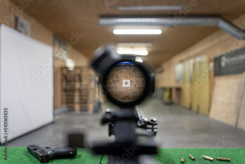 Firearms, view through the optical sight of a sniper rifle at a target in a shooting range. photo